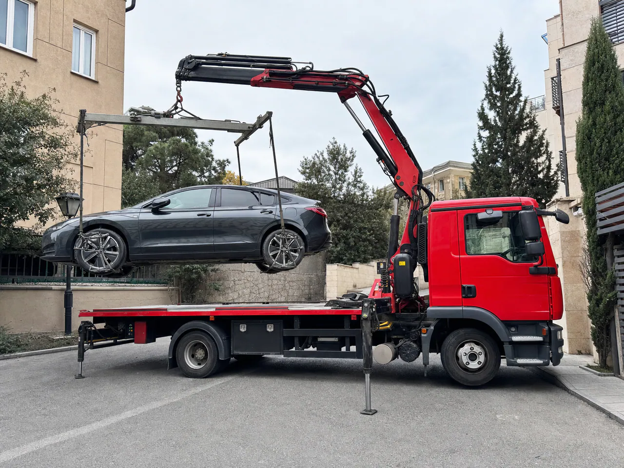 European spider tow truck using a crane-manipulator and four-wheel lifting frame to load a car in Georgia